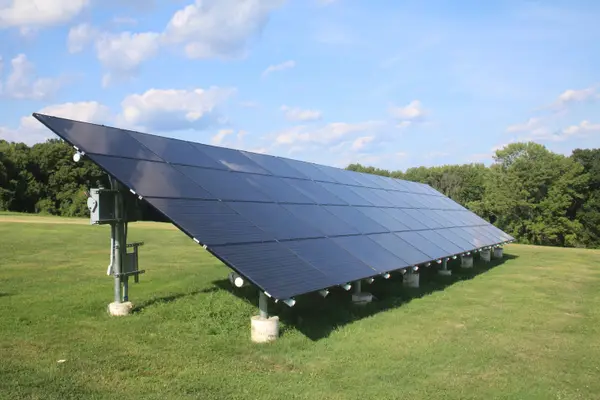 Ground-mounted solar panel array installed in an open landscape clearing