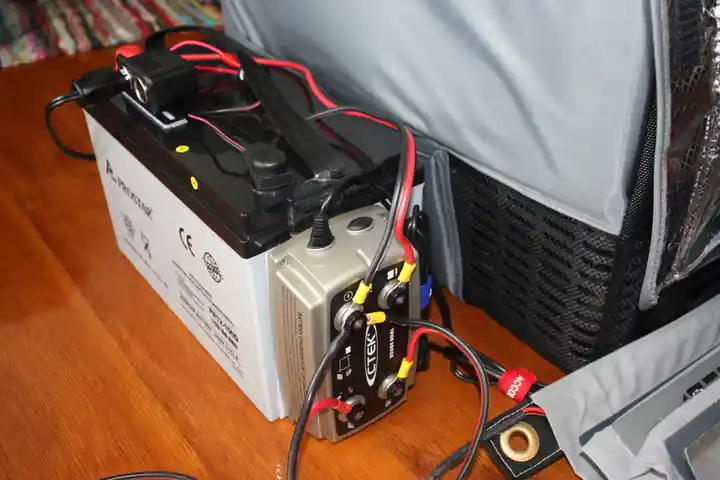 Auxiliary DC battery charging and conversion center installed inside an enclosure