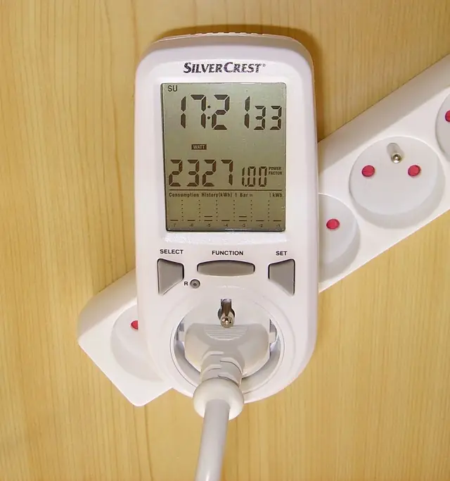 Digital plug-in wattmeter measuring appliance running wattage and cumulative energy consumption